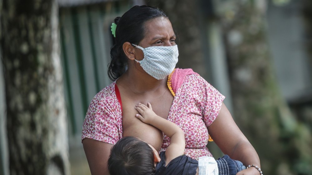 mère qui allaite avec un masque facial