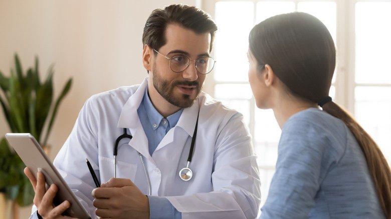 Une jeune femme parle avec son médecin