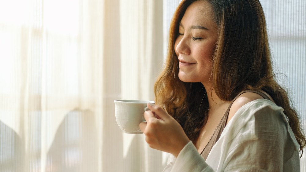 femme appréciant l'odeur du café