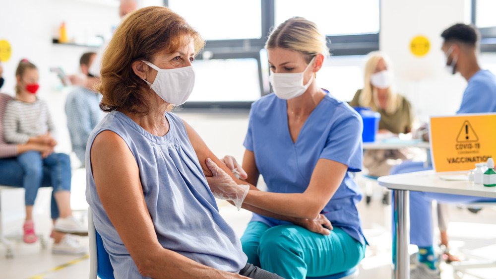 femme se faisant vacciner contre la COVID-19