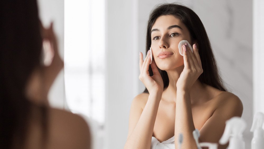 Femme utilisant de l'eau micellaire 