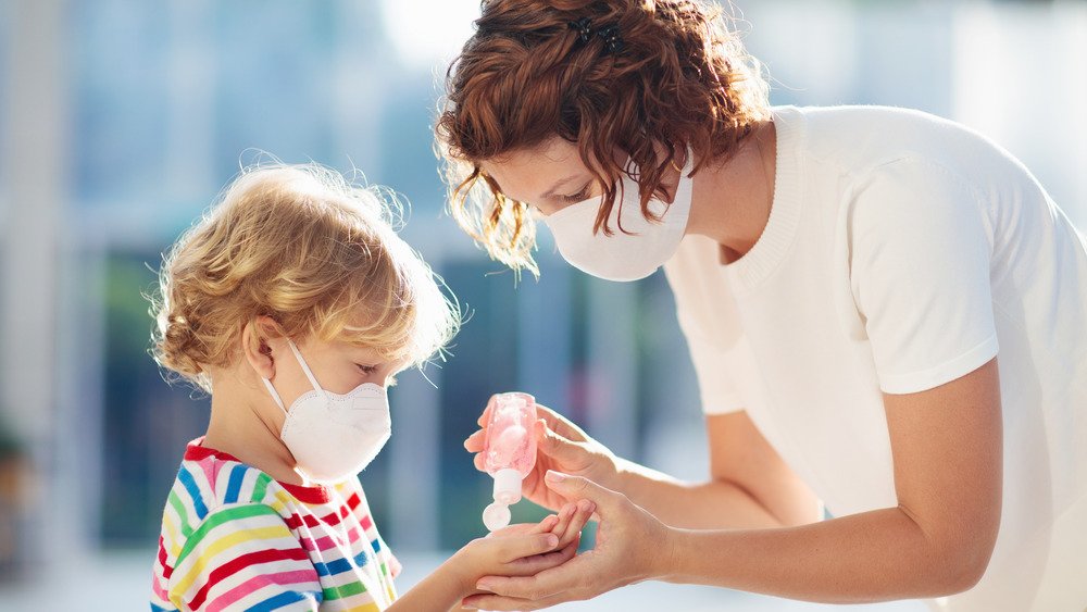 Une mère verse du désinfectant pour les mains dans la paume de son enfant