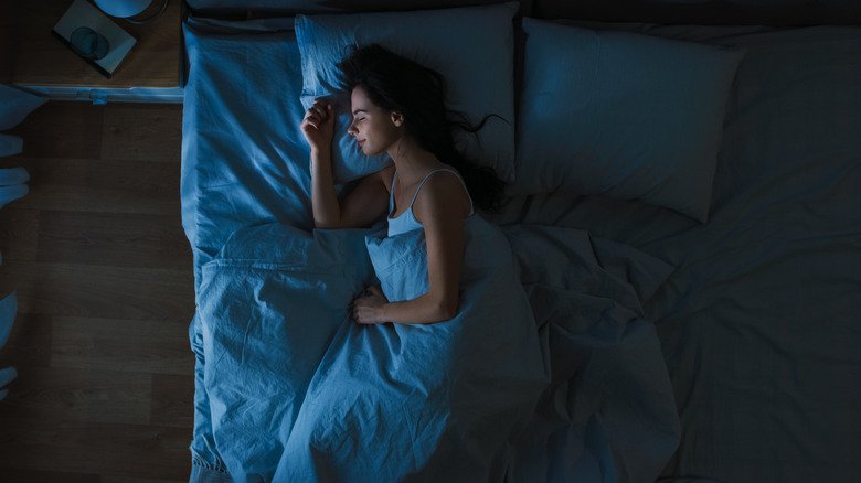 Vue de dessus d'une femme endormie dans son lit