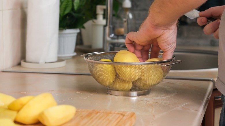 Préparation à la main de pommes de terre crues