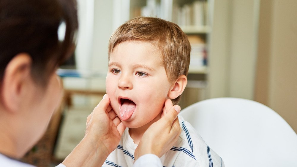 Médecin vérifiant la langue d'un enfant