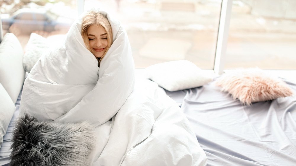 femme enveloppée dans une couette