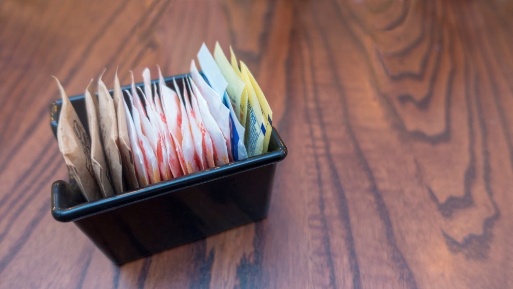 sachets blancs, roses, bleus, marron, édulcorants artificiels et sucre pour café, thé et boissons