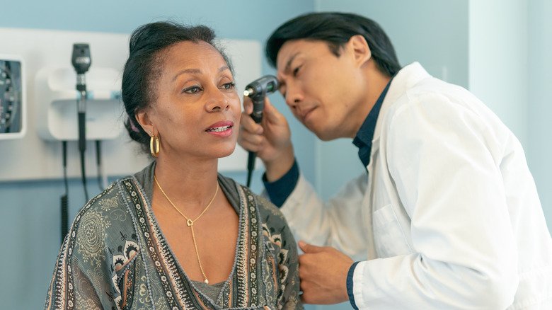 Médecin examinant l'oreille d'un patient