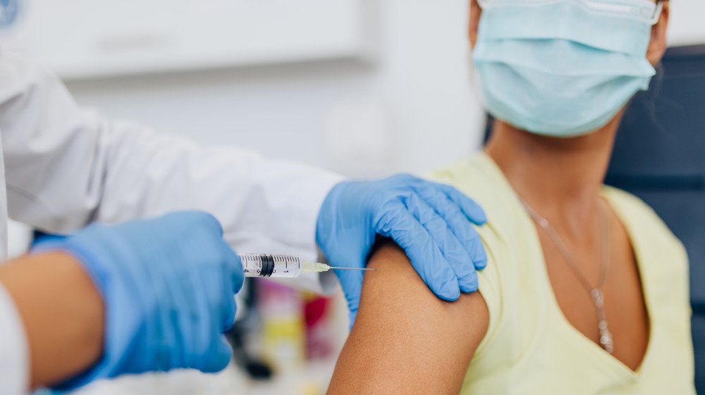 une femme se fait vacciner contre la grippe