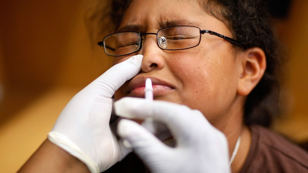 Une femme reçoit un vaccin nasal