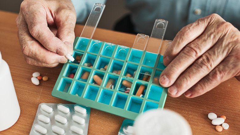 homme organisant ses pilules quotidiennes