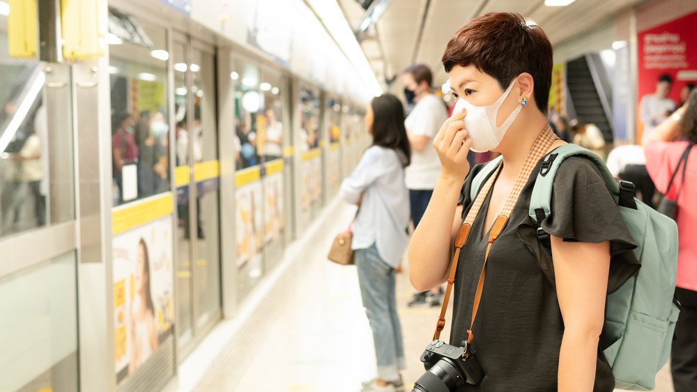 femme portant un masque attendant de monter dans un train 