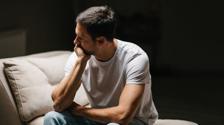 Homme triste et pensif assis sur une chaise