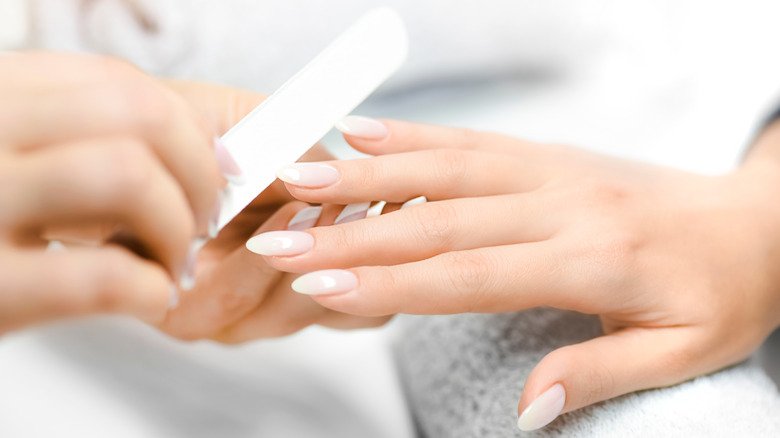 Femme ayant des ongles limés au salon