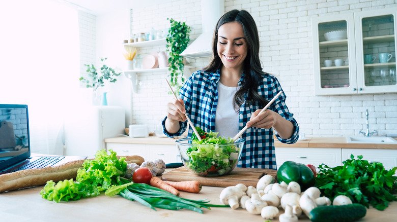 Une femme prépare une salade à la maison